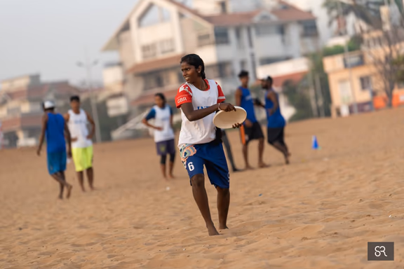 Selvi playing frisbee on the beach