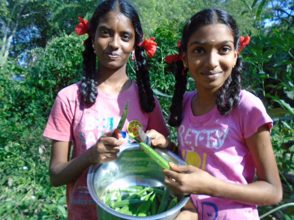 Udavi students proudly display the harvest